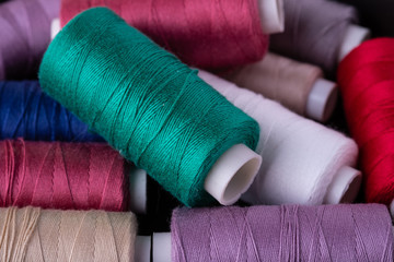 Top view close up of scattered colorful cotton thread coils
