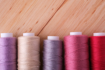 Row view close up of scattered colorful cotton thread coils