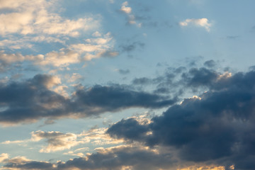 Blue sky at sunset with colorful clouds. Blue, yellow, white, gray and dark blue. Beautiful nature concept for design