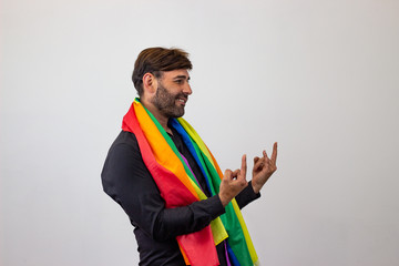 Portrait of handsome young man with gay pride movement LGBT Rainbow flag and brown hair vulnerable,...