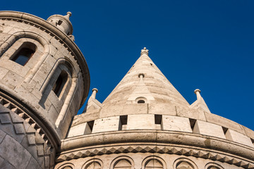 Hungary, Budapest, Castle Hill, Fischerbastei: Detail close up view of famous Fisherman's Bastion from below near Matthias Church above the city center of the Hungarian capital with blue sky - travel.