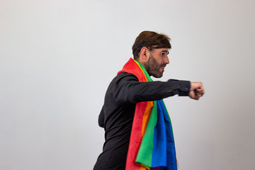 Portrait of handsome young man with gay pride movement LGBT Rainbow flag and brown hair at a party,...