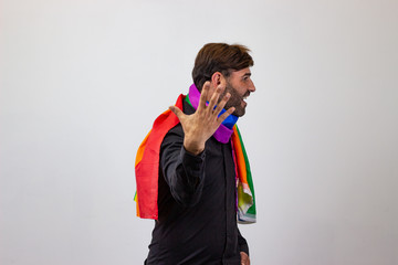 Portrait of handsome young man with gay pride movement LGBT Rainbow flag and brown hair giving a punch, facing forwards and looking at the side. Isolated on white background.