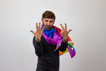 Portrait of handsome young man with gay pride movement LGBT Rainbow flag and brown hair searching...