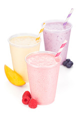Three Flavors (Mango, Raspberry, Blueberry) of Blended Yogurt and Fruit Smoothies with Striped Straws Isolated on White Background