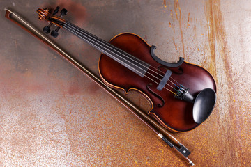 Fototapeta premium Classical violin on rusty background. Studio shot of old violin. Classical musical instrument