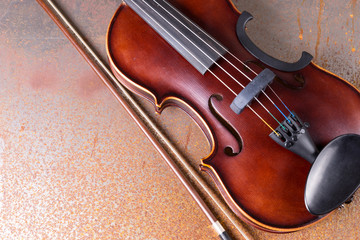 Fototapeta premium Classical violin on rusty background. Studio shot of old violin. Classical musical instrument