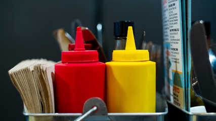 A close up of a traditional bottle of ketchup and mustard, this classic design of bottle is...
