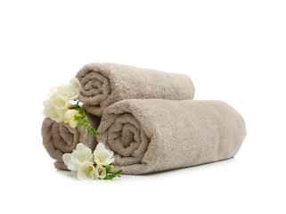 Fototapeta na wymiar Clean rolled towels with flowers on white background