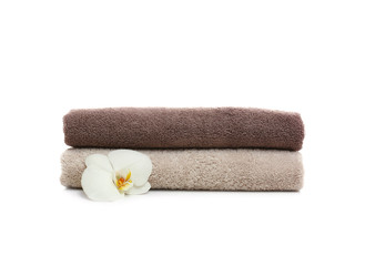 Fototapeta na wymiar Clean folded towels with flower on white background