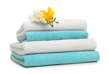 Obraz na płótnie Canvas Stack of clean folded towels with flowers on white background