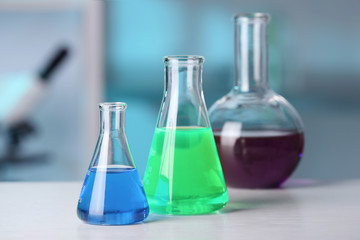 Laboratory glassware with samples on table indoors. Solution chemistry