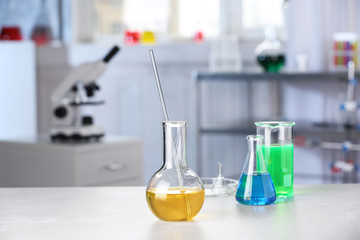 Laboratory glassware with samples on table indoors, space for text. Solution chemistry
