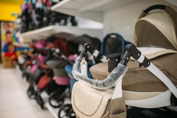 Many baby strollers on shelf in store closeup view