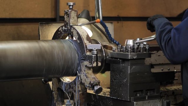 Turning lathe in action.Facing operation of a metal blank on turning machine with cutting tool.Old turning lathe machine in turning workshop.Operator machining high precision mold part by cnc lathe