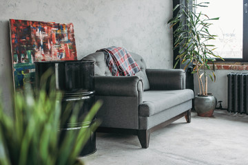 Modern eco loft interior in living room, concrete floor, sofa, minimalism studio