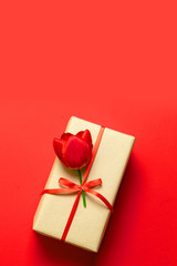 Brown gift box with red bow on wood table, top view