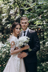 Walk newlyweds with a bouquet of white flowers.