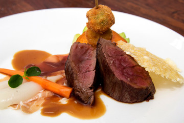 Gourmet dish with fillet of calf, carrot, prosciutto and vegetables fried 
