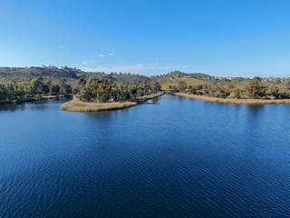 Fototapeta premium Aerial view of Miramar reservoir in the Scripps Miramar Ranch community, San Diego, California. Miramar lake, popular activities recreation site including boating, fishing, picnic & 5-mile-long trail.