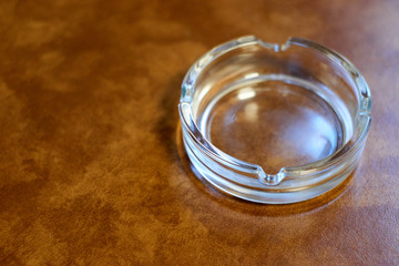 木目のテーブルにガラスの灰皿