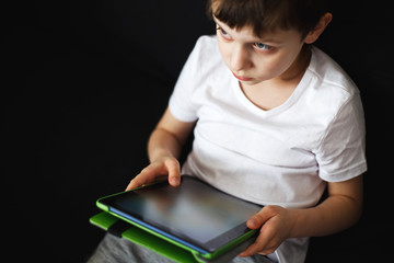 Fototapeta premium boy sits with a tablet in hand