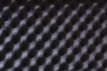 Texture of acoustic foam rubber. Abstract dark gray background with cells. Materials for sound and...