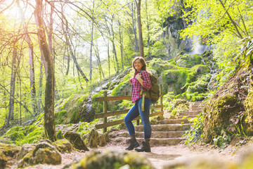 Naklejka na ściany i meble Hiker woman with backpack walking on path in summer forest