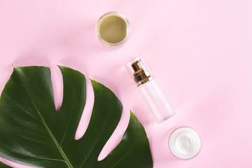 Moisturizing care skincare face cream for healing complicated troubled skin type in an open jar with visible texture. Copy space, close up, background, flat lay, top view. Monstera leaf decoration.