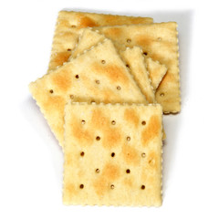 Looking down at stack of soda crackers, also known as soup crackers and saltines over white, not isolated.