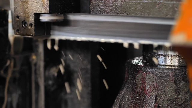 Industrial metal machining cutting process of blank detail by mechanical electrical saw.