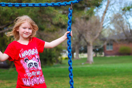 Red Headed Girl On A Park Swing