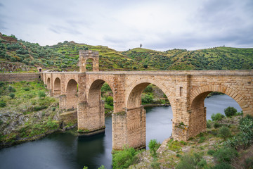 Fototapeta na wymiar The Alcantara Bridge also known as Trajan Bridge at Alcantara is a Roman bridge at Alcantara, in Extremadura, Spain. Slow shutter speed shot.