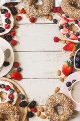 Whole meal bagels with cream cheese and fresh berries served on wooden table. Healthy breakfast concept. Cafe or bakery menu