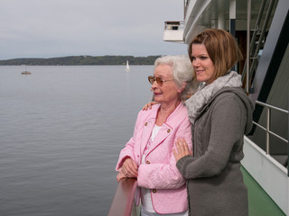 Glückliche Seniorin mit Betreuerin beim Ausflug am See