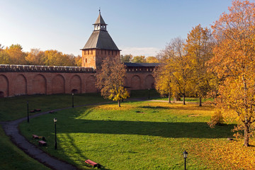 View of the fortress wall of the Novgorod Kremlin surrounded by autumn colors of trees.
