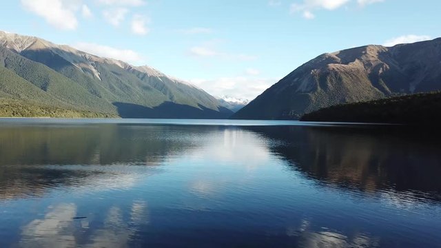 Flying low over the calm pure water of Lake Rotoiti in New Zealand 4k
