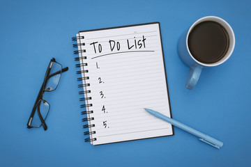 To Do List on Notebook over Pastel Blue Background