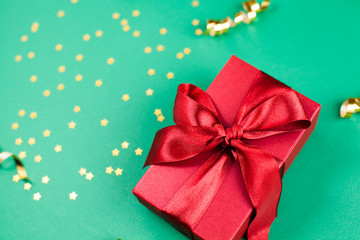 gift box and Golden decorations and sparkles on bright  green background