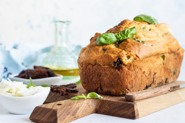 Savoury loaf cake with dried tomatoes, mozzarella and basil. Selective focus.