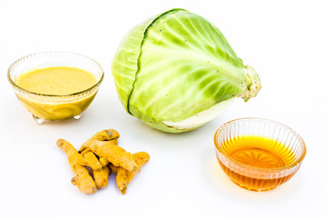 Cabbage face mask isolated on white consisting of cabbage juice well mixed with honey and turmeric in a glass bowl and entire raw ingredients present on the surface.Used to remove infections and tans.