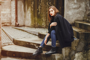 Beautiful girl in a city.Woman with phone. Lady sitting on a stairs