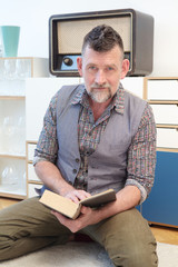 handsome man in his 50s reading a book