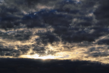 Obraz premium Blue sky with gold clouds - dramatic sunset, beautiful natural background. Setting sun illuminates the clouds.