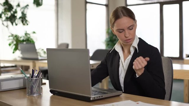 Female employee feeling wrist pain after typing on laptop, inflammation of joint