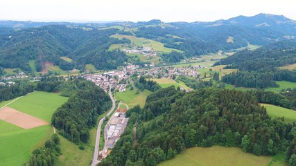 Lift up drone shot from a little village, direction of Bauma, Switzerland. Also visible an old spinning factory from the industialisation.