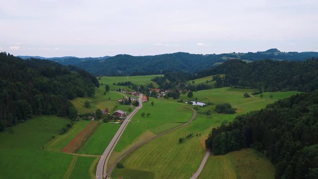 Lift up drone shot from a little village, direction of Bauma, Switzerland. Also visible an old spinning factory from the industialisation.