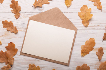 Autumn leaves and envelope on a white wooden background