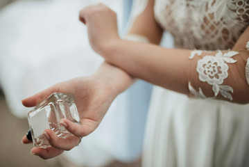 Obraz na płótnie Canvas bride in wedding dress enjoys a perfume close-up
