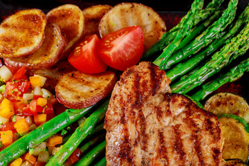 Grilled chicken breast with vegetables on a roasting tomato and asparagus potatoes